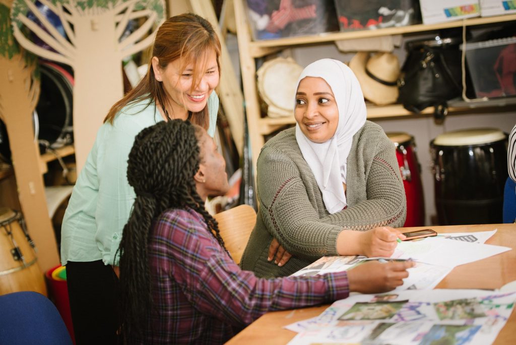 Three women sat at a table smiling