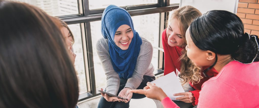 Women sat in a circle talking and laughing