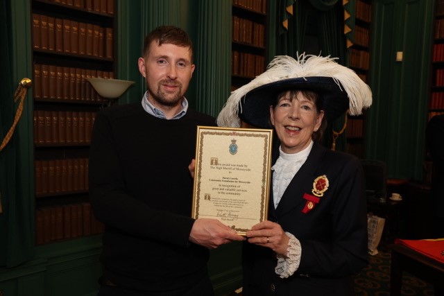 Man being presented with a High Sheriff Award by a woman