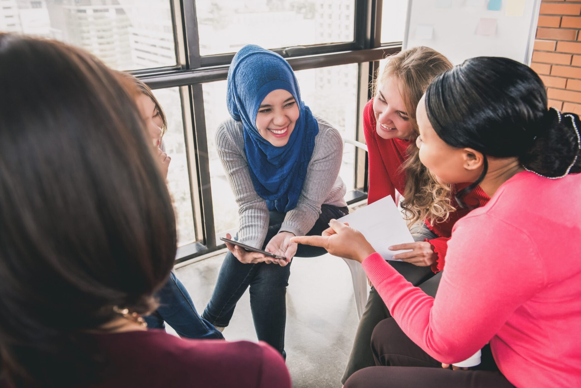 Group of women talking and smiling while sitting in a circle