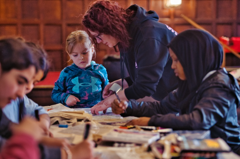 Woman helping children with a crafting activity