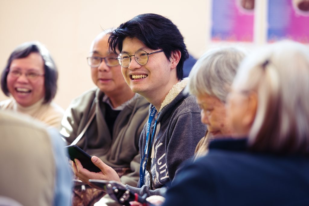 Smiling man wearing a lanyard at a community centre event