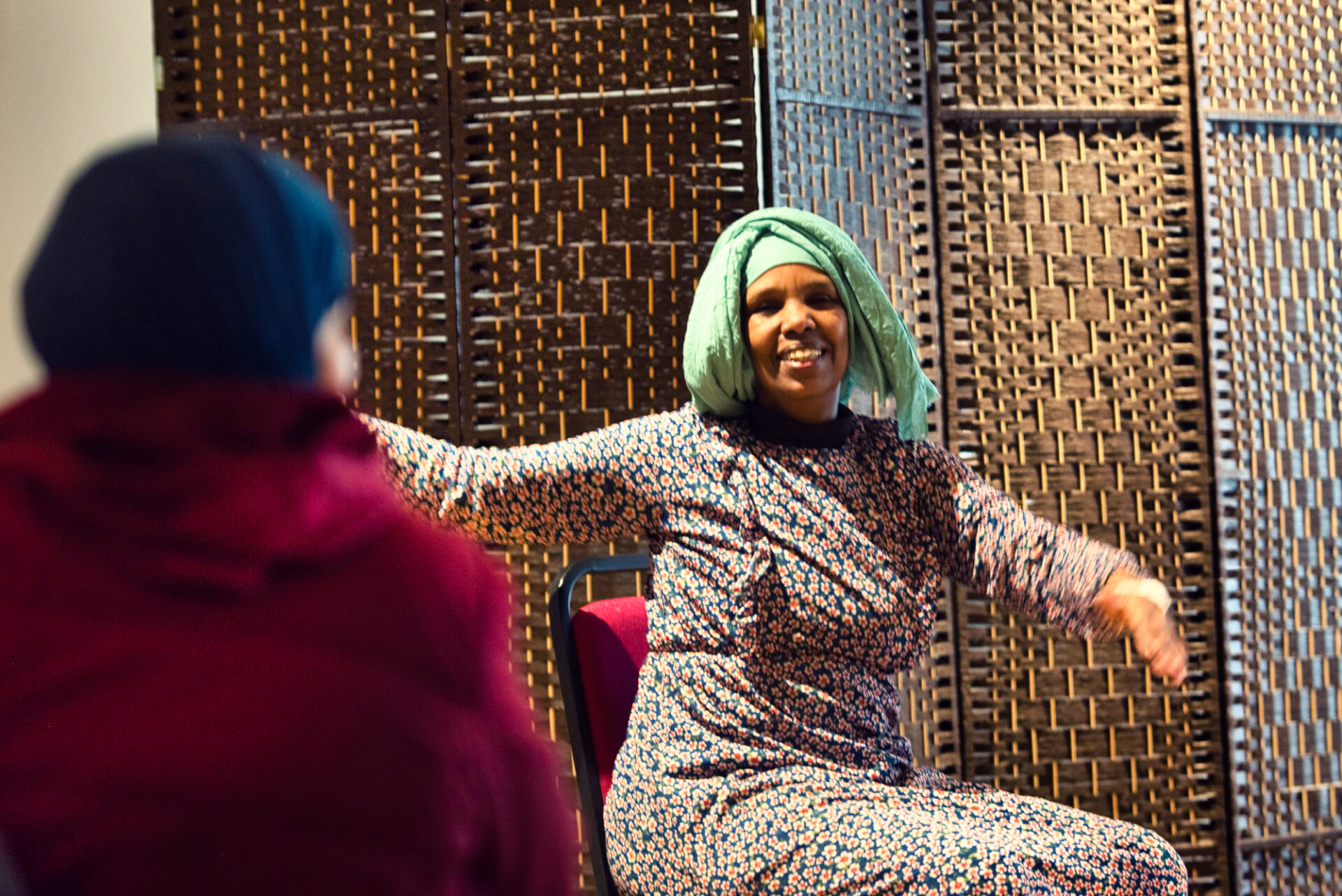 A women smiling while sitting on a chair