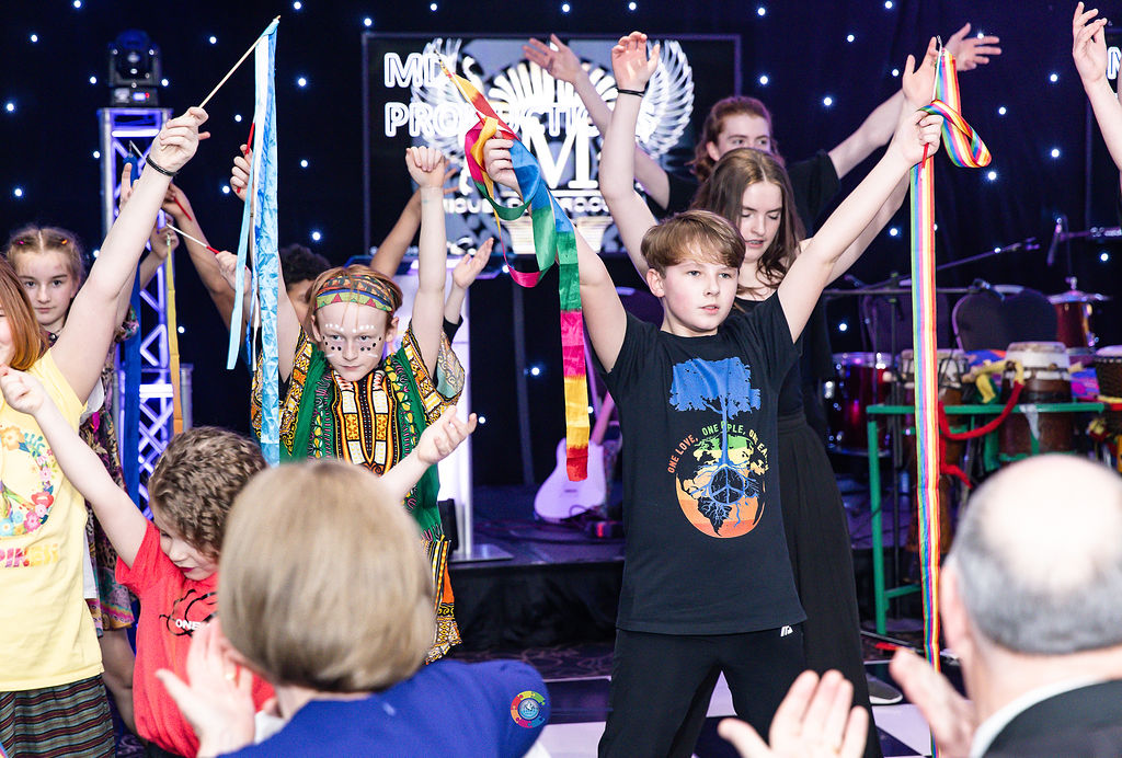 Children standing in costumers on a stage